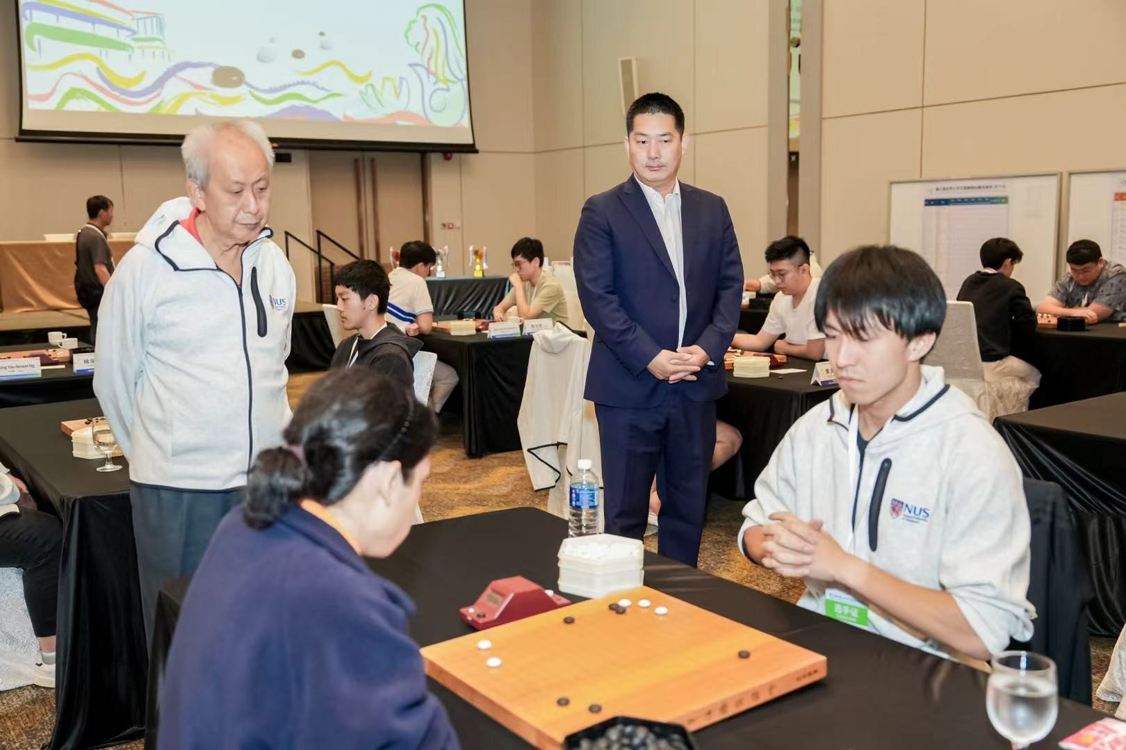 中国围棋协会主席(xí)常(cháng)昊(hào)（右(yòu)二(èr)）、新(xīn)加(jiā)坡(pō)围棋协会会长陈丁川（左一）观战。中国围棋协会供图